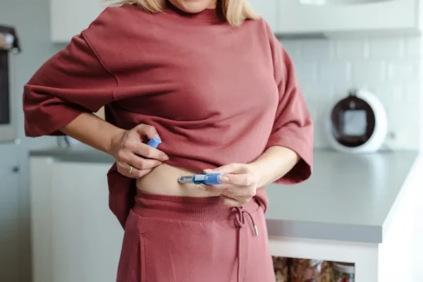 Mulher aplicando insulina na barriga