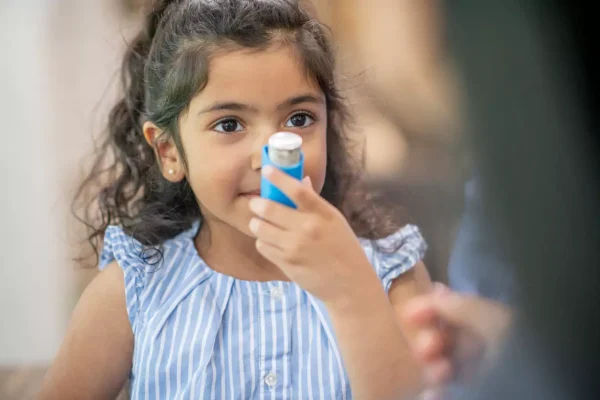 criança com inalador de asma na boca