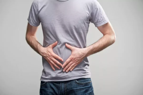 homem segurando a barriga, tentando evitar a dor da Gastroenterite aguda
