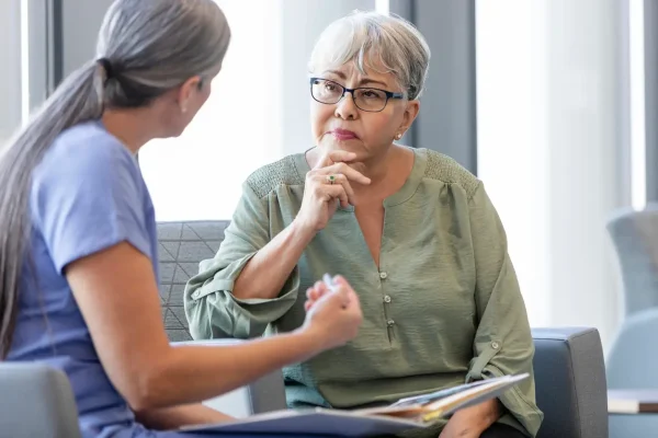 Mulher idosa ouve atentamente enquanto médica explica diagnóstico