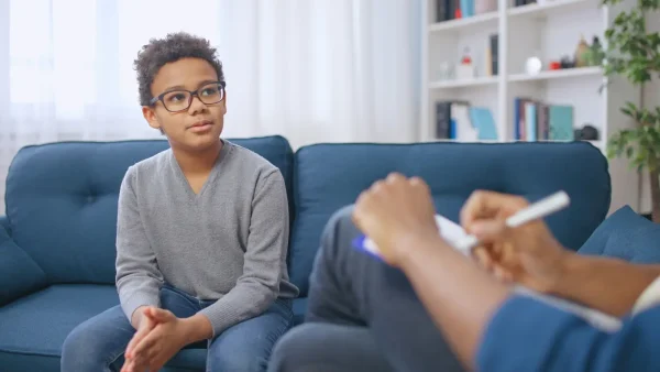 Saúde mental na infância e adolescência
Menino pré-adolescente afro-americano conversando com psicólogo escolar, terapia infantil 