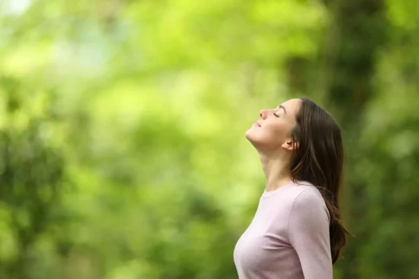 mudar sua qualidade de vida - mulher respirando na natureza