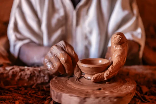 Mãos de um ceramista manuseando cerâmica