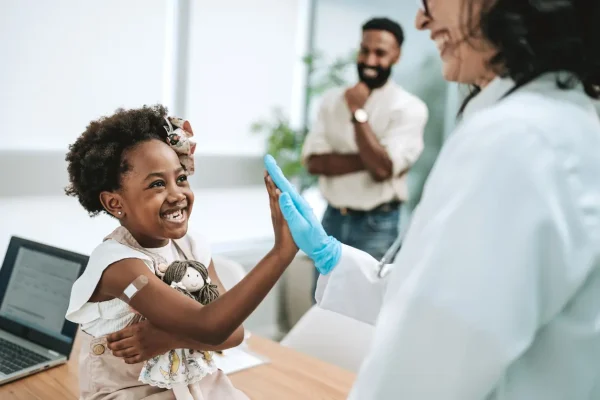 Médico parabenizando criança que seguiu o calendário de vacinação