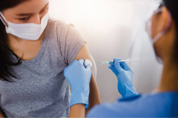 Médico aplicando vacina em criança seguindo o calendário de vacinação
