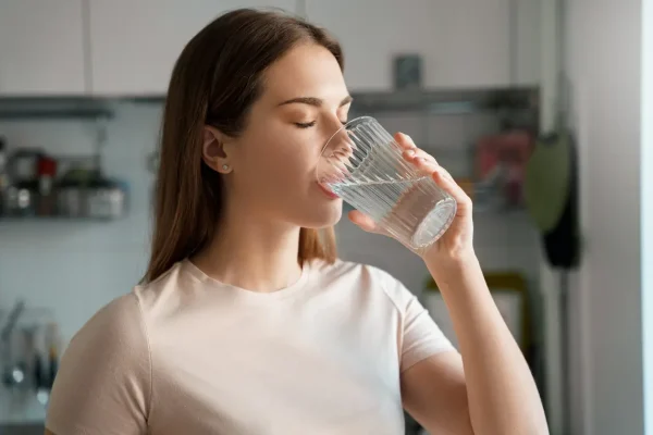Mulher bebendo água por conta da onde de calor do El Niño